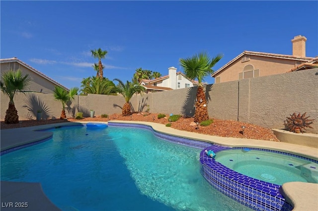 view of pool with a fenced backyard and a pool with connected hot tub