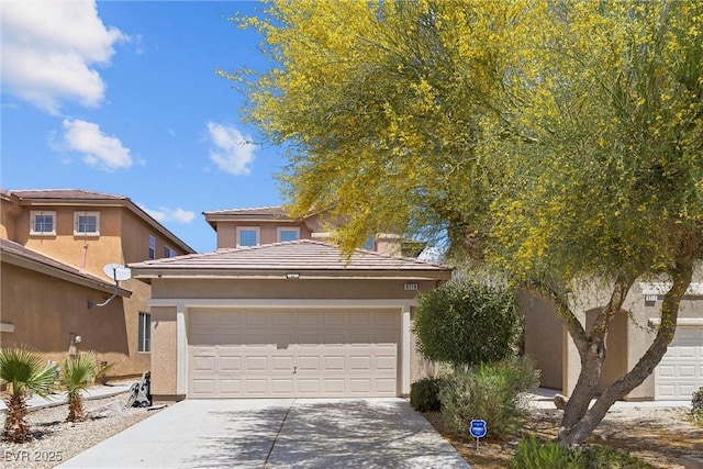 view of front of house featuring driveway, an attached garage, and stucco siding