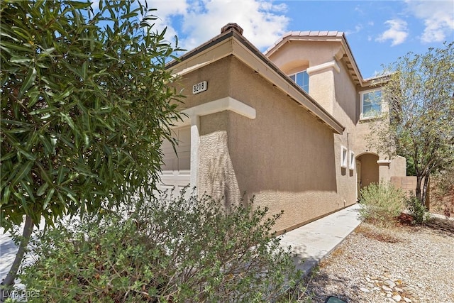 view of home's exterior with stucco siding and a garage