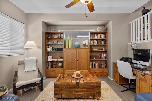 office area featuring light wood-type flooring, ceiling fan, and baseboards