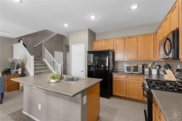 kitchen with black appliances, a sink, a kitchen island with sink, and recessed lighting