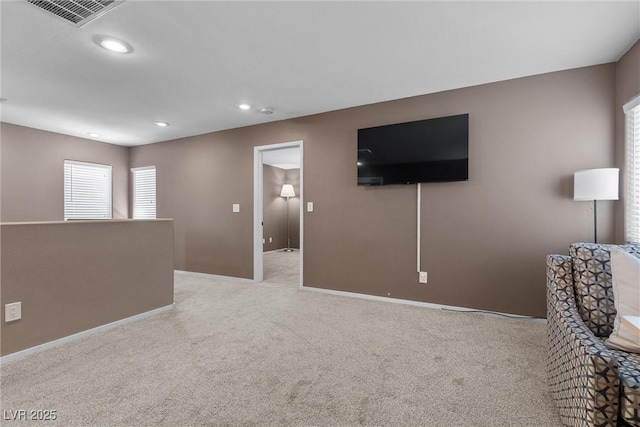 living room featuring baseboards, plenty of natural light, light colored carpet, and recessed lighting