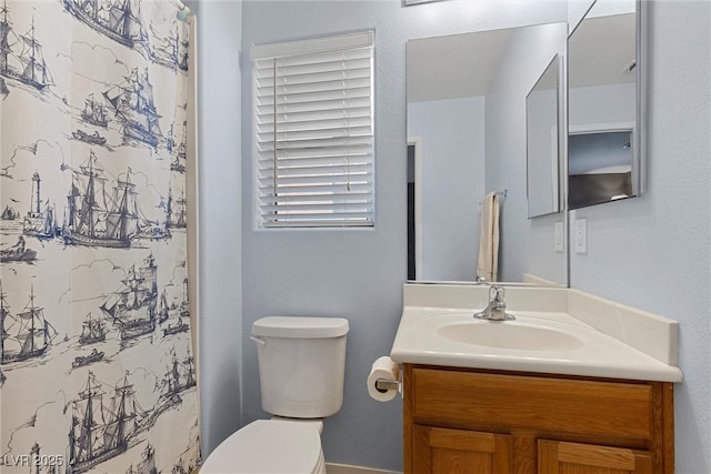 full bath featuring toilet, vanity, and curtained shower