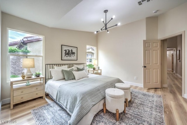 10205 Birch Bluff Ln, Las Vegas, NV 89145 - bedroom with a chandelier, multiple windows, light wood finished floors, and high vaulted ceiling