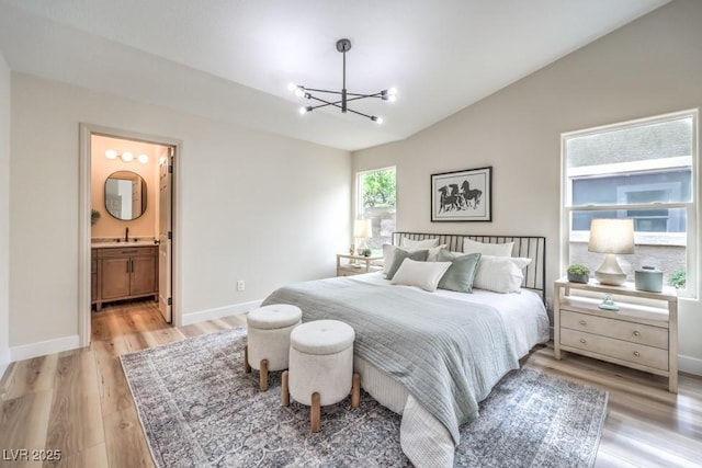 10205 Birch Bluff Ln, Las Vegas, NV 89145 - bedroom featuring a chandelier, lofted ceiling, light wood-type flooring, baseboards, and ensuite bathroom
