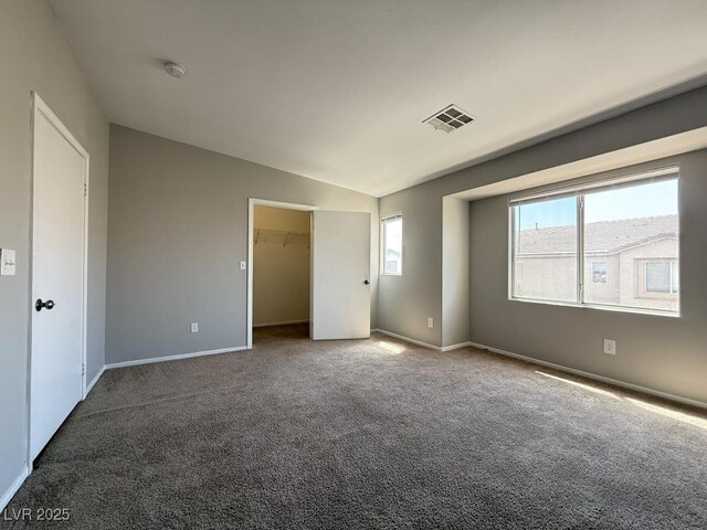 2105 William Holden Ct, Las Vegas, NV 89142 - unfurnished bedroom with visible vents, carpet floors, baseboards, a walk in closet, and vaulted ceiling