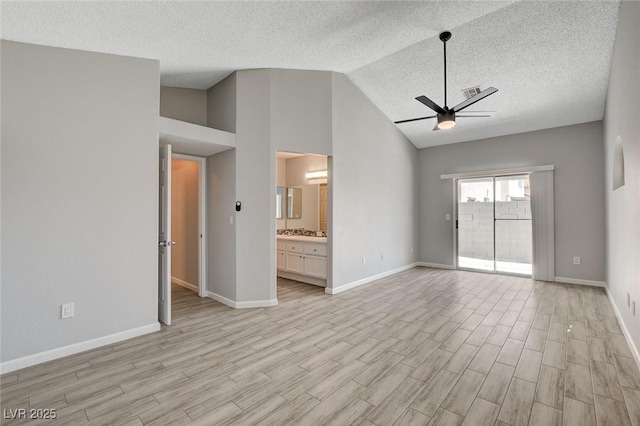 unfurnished living room with a ceiling fan, a textured ceiling, baseboards, and light wood-style floors