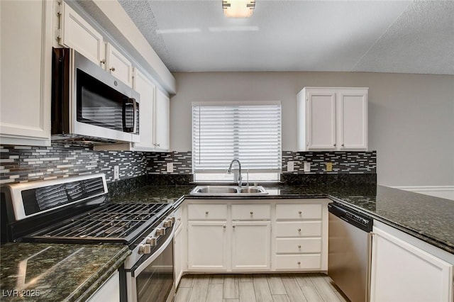 kitchen featuring a sink, white cabinets, stainless steel appliances, and tasteful backsplash