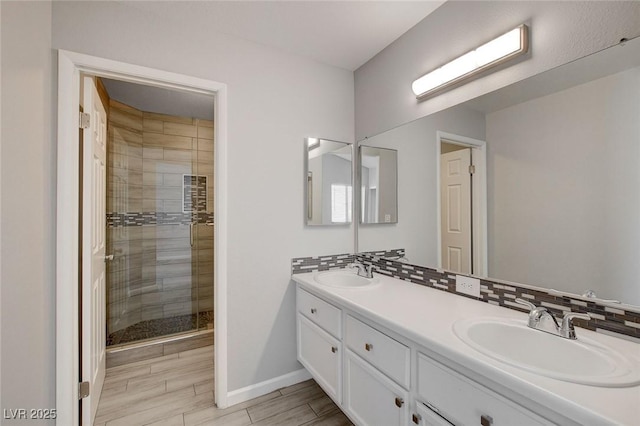 bathroom with a sink, baseboards, a stall shower, and wood finish floors