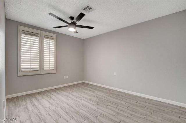 unfurnished room featuring ceiling fan, a textured ceiling, visible vents, wood finished floors, and baseboards