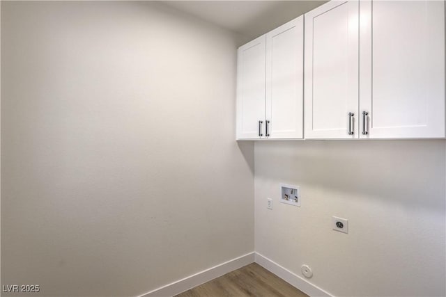 laundry room featuring washer hookup, electric dryer hookup, light wood-type flooring, cabinet space, and baseboards