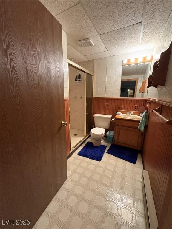 1090E 15th St, Ely, NV 89301 - full bath featuring vanity, toilet, a drop ceiling, tile patterned floors, and a shower stall