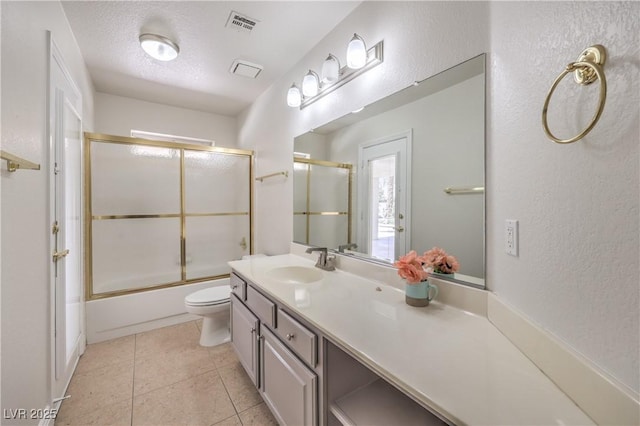 full bath featuring a textured wall, tile patterned flooring, vanity, toilet, and visible vents
