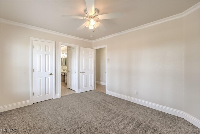 unfurnished bedroom with light colored carpet, a ceiling fan, baseboards, ensuite bathroom, and ornamental molding