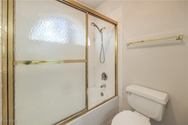 full bath with toilet and shower / bath combination with glass door