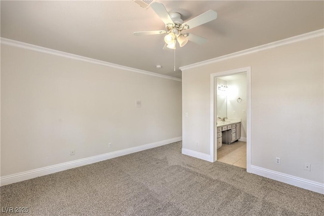 unfurnished bedroom with ceiling fan, light colored carpet, crown molding, baseboards, and ensuite bathroom