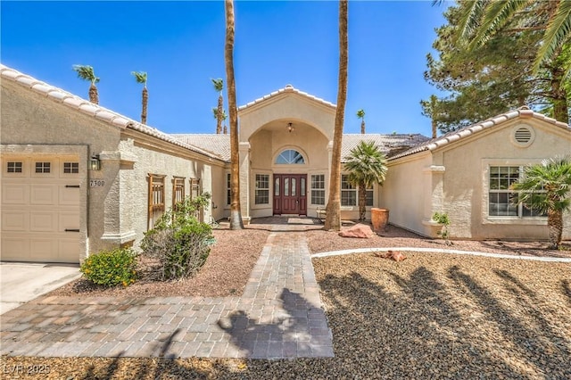 view of front of home with a garage and stucco siding