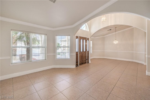 interior space with crown molding, arched walkways, baseboards, and light tile patterned floors