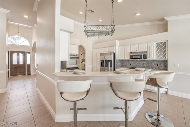 kitchen with visible vents, decorative backsplash, light tile patterned flooring, and stainless steel appliances