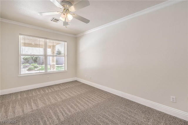 carpeted spare room featuring crown molding, baseboards, a ceiling fan, and visible vents