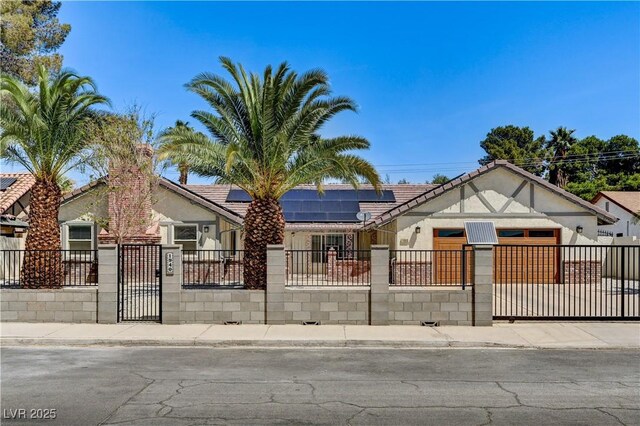 view of front of property featuring a fenced front yard, solar panels, and stucco siding