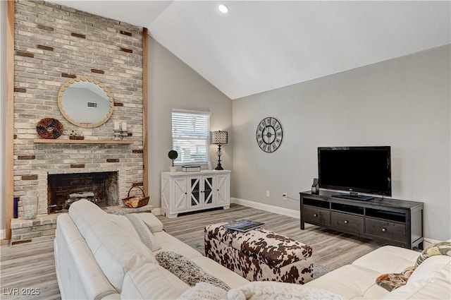 living room with a brick fireplace, high vaulted ceiling, baseboards, wood finished floors, and visible vents