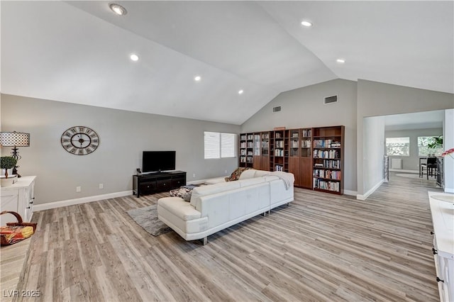 living room featuring visible vents, plenty of natural light, and light wood-style floors