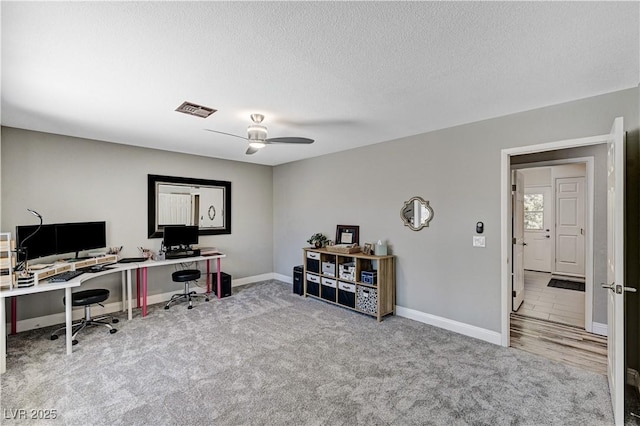 office space with carpet floors, a ceiling fan, baseboards, and visible vents