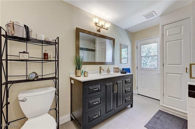bathroom featuring tile patterned flooring, vanity, toilet, baseboards, and visible vents