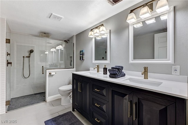 bathroom with toilet, visible vents, a sink, and tile patterned flooring
