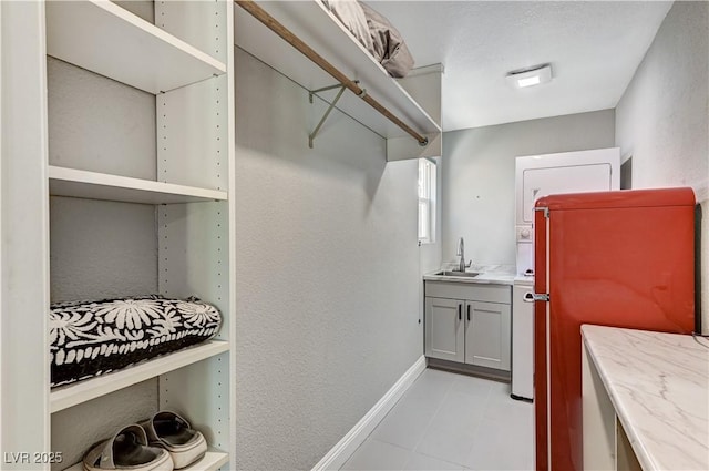 walk in closet featuring light tile patterned flooring and a sink