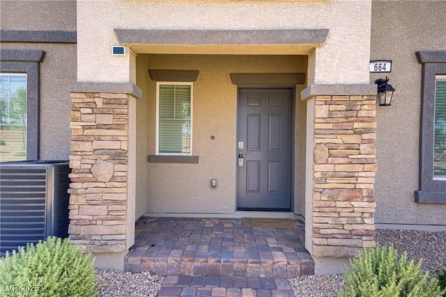 664 Foam Flower Ln, Henderson, NV 89015 - view of exterior entry with stone siding, central AC, and stucco siding