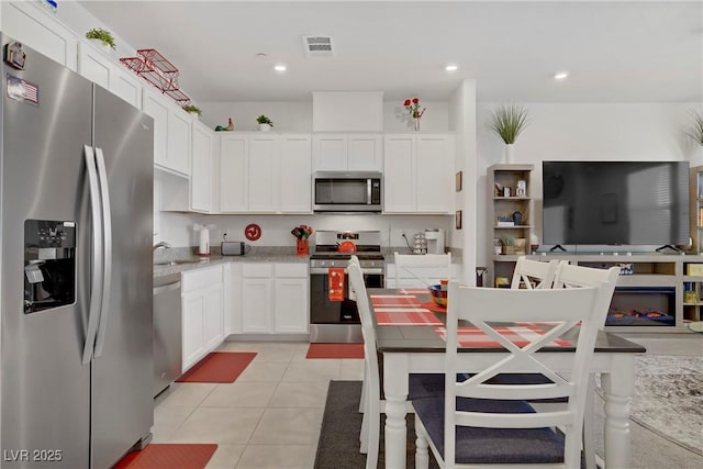 664 Foam Flower Ln, Henderson, NV 89015 - kitchen featuring stainless steel appliances, white cabinetry, a sink, light tile patterned flooring, and light stone countertops