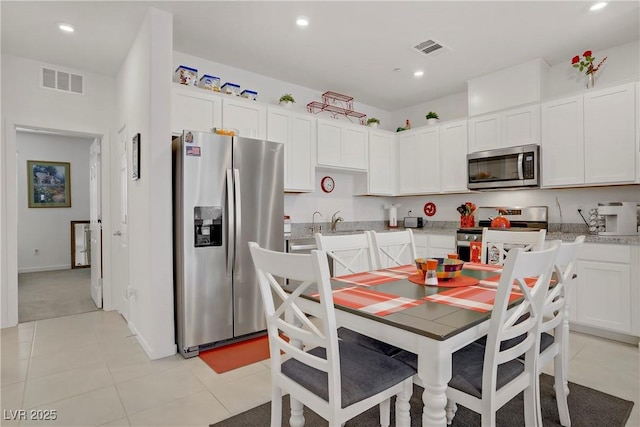 664 Foam Flower Ln, Henderson, NV 89015 - kitchen with appliances with stainless steel finishes, white cabinets, recessed lighting, light tile patterned floors, and light stone counters