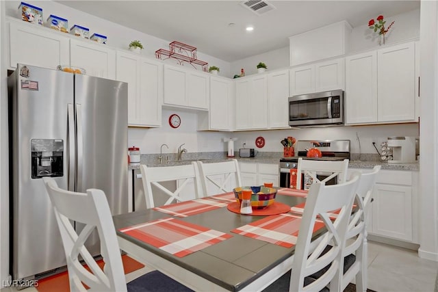 664 Foam Flower Ln, Henderson, NV 89015 - kitchen featuring stainless steel appliances, white cabinetry, light tile patterned floors, and recessed lighting
