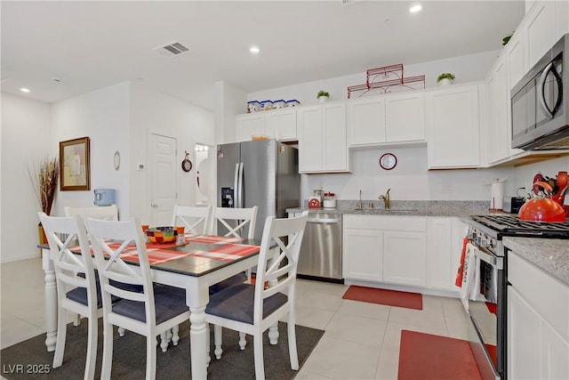 664 Foam Flower Ln, Henderson, NV 89015 - kitchen featuring appliances with stainless steel finishes, white cabinets, light stone countertops, light tile patterned floors, and recessed lighting