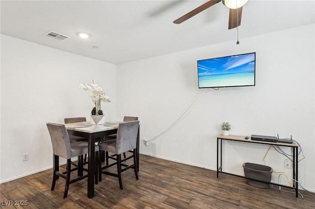 dining room featuring baseboards, ceiling fan, visible vents, and wood finished floors