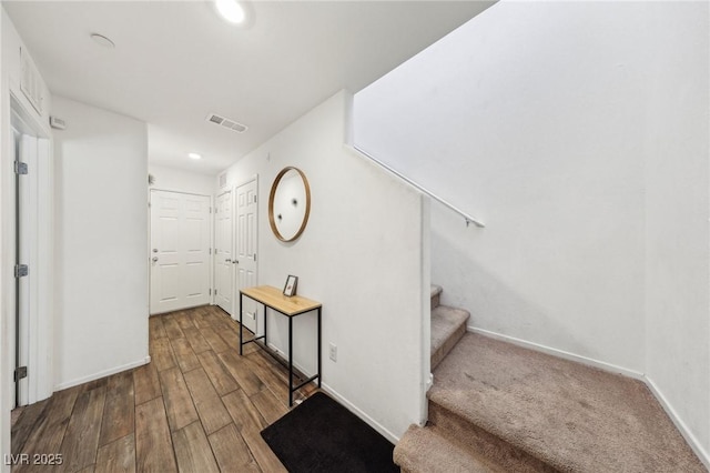 staircase with baseboards, recessed lighting, wood finished floors, and visible vents