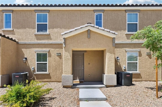 view of front facade with central AC unit and stucco siding