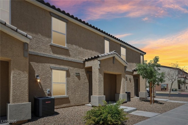 property at dusk with cooling unit