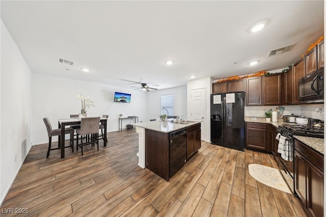 kitchen featuring a kitchen island, ceiling fan, visible vents, and black appliances