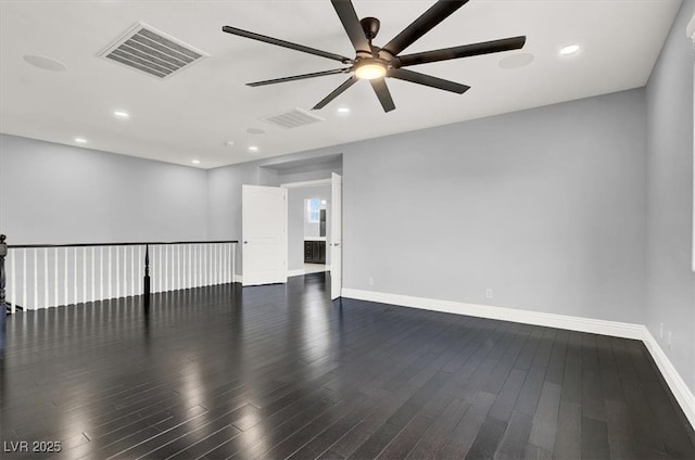 empty room with ceiling fan, visible vents, baseboards, and dark wood-type flooring