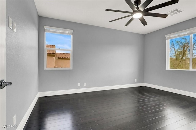 spare room with visible vents, dark wood-style flooring, ceiling fan, and baseboards