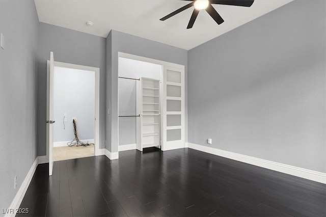 interior space featuring a ceiling fan, baseboards, and dark wood finished floors