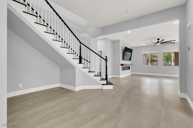 interior space featuring baseboards, recessed lighting, ceiling fan, and stairway