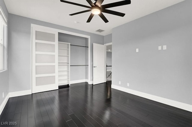 unfurnished bedroom featuring a ceiling fan, baseboards, wood finished floors, visible vents, and a closet