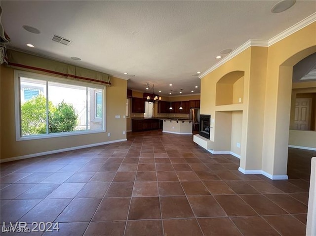 unfurnished living room featuring visible vents, ornamental molding, baseboards, recessed lighting, and dark tile patterned flooring