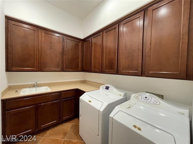 washroom featuring a sink, cabinet space, light tile patterned floors, and washing machine and dryer