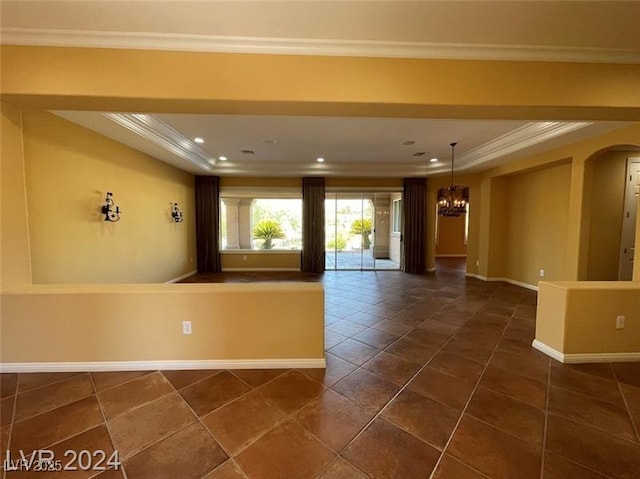 unfurnished room with a tray ceiling, a notable chandelier, and ornamental molding