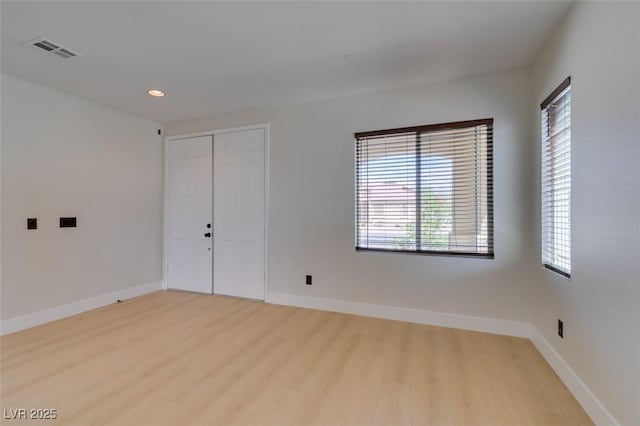 empty room featuring baseboards, recessed lighting, light wood-style flooring, and visible vents